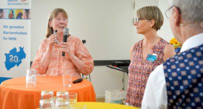 zwei Frauen am Stehtisch, eine Frau spricht in ein Mikrofon