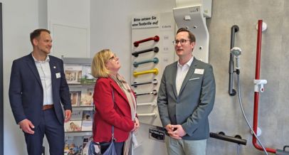 Landrat Jan-Christoph Schaberick (re.) und die stellvertretende Bürgermeisterin und MdL Kirsten Stich probieren den Körperföhn aus, der nach dem Duschen Menschen mit Behinderung hilft, sich zu trocknen (links: Joel Stieglitz vom Ennepe-Ruhr-Kreis)