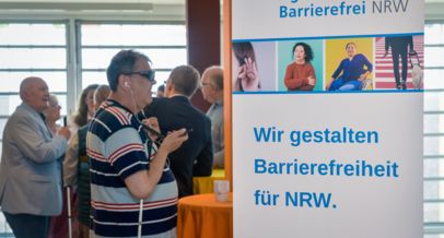 Gäste vor einem Agentur-Plakat