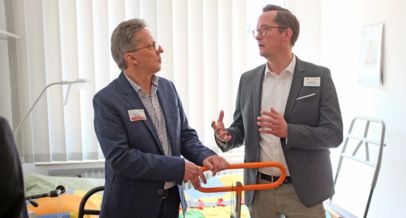 Wohnberater Hans-Werner Geburek (li.) zeigt Landrat Jan-Christoph Schaberick verschiedene Hilfsmittel für die Betreuung von pflegebedürftigen Menschen