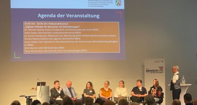 Foto auf das Podium "Digitale Teilhabe für Menschen mit Behinderung" beim Fachtag für alle. Auf dem Podium sitzt unter anderem Annika Nietzio von der Agentur Barrierefrei NRw und sechs weitere Menschen.