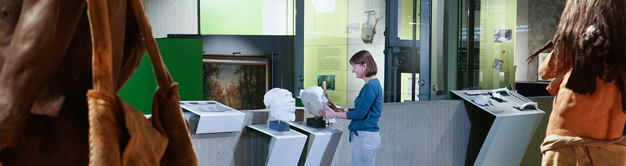 Eine Frau berührt ein 3D Tastobjekt in Form eines Schädels