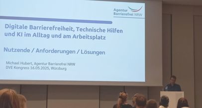 Agentur Mitarbeitender Michael Hubert am Referentenpult vor Zuhörenden